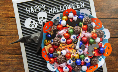 decorated holiday table Halloween Jack o Lantern candy bowl  with sweets and halloween cookies Trick or Treat dark background