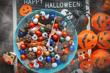 decorated holiday table Halloween Jack o Lantern candy bowl  with sweets and halloween cookies Trick or Treat dark background