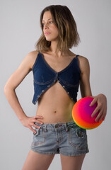 Woman in Jean Outfit Holding Colorful Rubber Ball