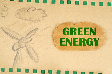 A wind generator and clouds are drawn on cardboard, next to it lies a cardboard with the inscription - Green energy