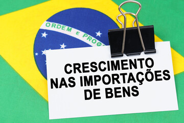 On the flag of Brazil lies a business card with the inscription - growth in imports of goods