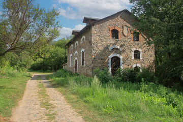 Fototapeta na wymiar The old building of a village mill on the river Southern Bug.