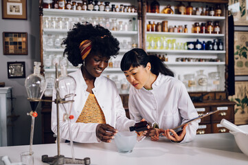 Multiracial pharmacists mix and make a cure in mortar.