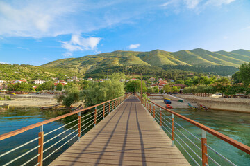 A picturesque wooden jetty on Shkodra Lake in Shkoder town of Albania. Shkodra wharf extends gracefully into the tranquil waters of Shkoder lake, offering a serene spot for lakeside relaxation and
