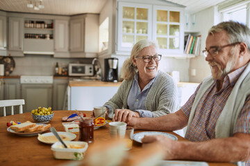 Senior Caucasian couple having breakfast together in the kitchen in the morning