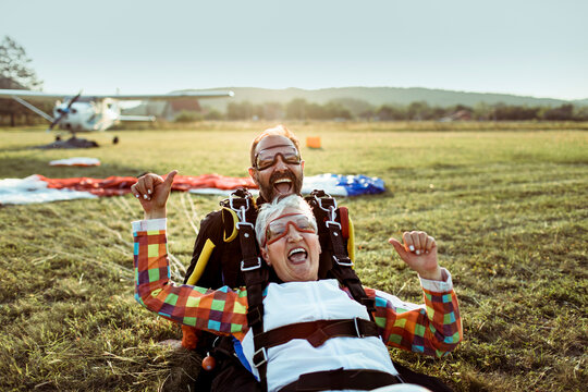 Senior female skydiver and her skydiving instructor landing after skydiving from a plane