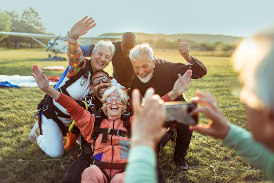 Group of senior friends getting their picture taken after skydiving together for their first time