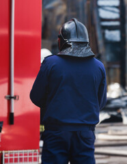 Group of fire men in protective uniform during fire fighting operation in the city streets,...