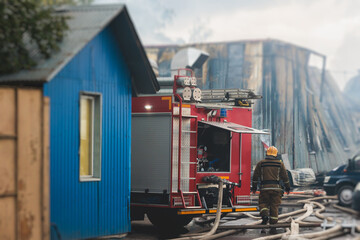 Group of fire men in protective uniform during fire fighting operation in the city streets,...