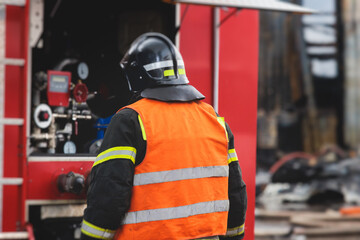 Group of fire men in protective uniform during fire fighting operation in the city streets,...