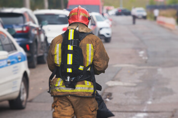 Group of fire men in protective uniform during fire fighting operation in the city streets,...
