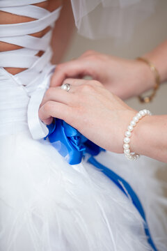 female hands tying a wedding bow on the bride's dress