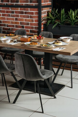 The food table is set with lunch dishes. Simple food, potatoes, cucumbers, meat. Side view.