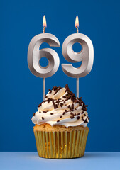 Vertical birthday card with cake - Lit candle number 69 on blue background