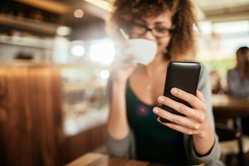 Young African American woman using a smartphone in a cafe