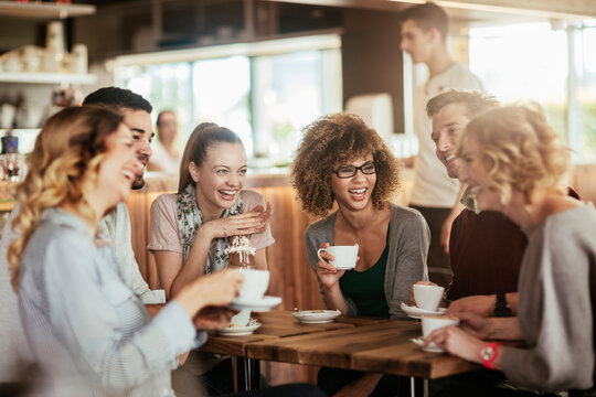 Young and diverse group of friends talking while having coffee together in a cafe - Powered by Adobe