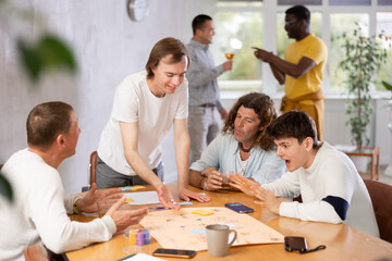 Group of men play board games during a friendly meeting indoors
