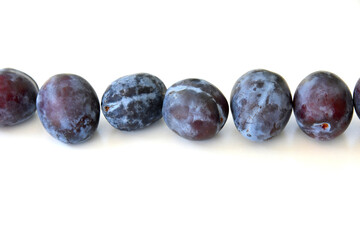 plums isolated on white background with shadows. A set of whole ripe fruits in blue, purple color with clear details and smooth blur. Fresh healthy food. Harvest from the garden.