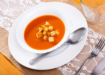 Healthy delicious lunch. Dietary creamy carrot soup blended to velvety-smooth consistency garnished with crispy toasted bread ..