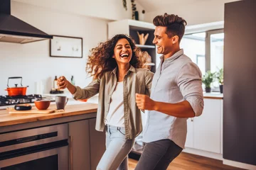 Poster Beautiful young latino couple dancing to music and having the time of their lives in living room © VisualProduction