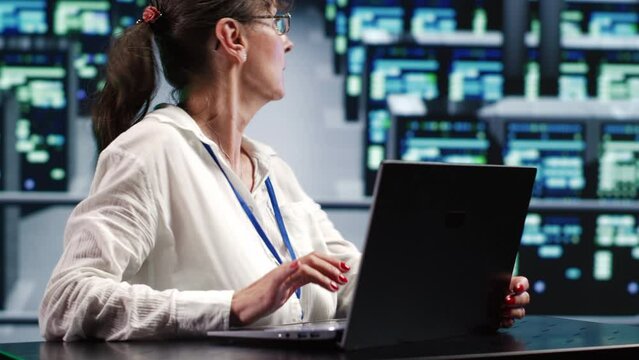 Dilligent inspector in cloud computing company headquarters housing high end blade servers capable of efficiently performing complex computations and data analysis, using tablet to ditch defects