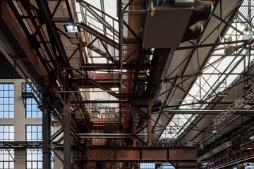  Low angle interior view of the ceiling with rusty steel structure and skylight of industrial...