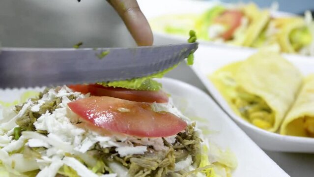Fonda de comida callejera, preparando tostada con carne y complementos.