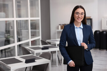 Happy real estate agent with leather portfolio indoors. Space for text