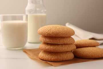 Delicious Danish butter cookies and milk on white marble table, closeup