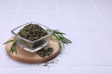 Dry and fresh tarragon on white tiled table, space for text