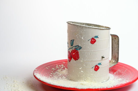 decorative flour sifter on red plate