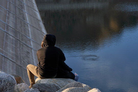 Young Couple Enjoying Lakeside View at Sunset by the Dam