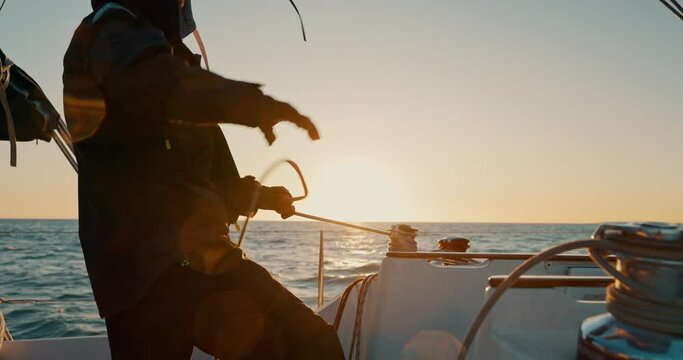 Sunset, boat and man pull anchor at ocean to travel, vacation or holiday outdoor. Tighten rope, sailing and person on ship, yacht and sailor cruise at sea in transportation on journey on mockup space
