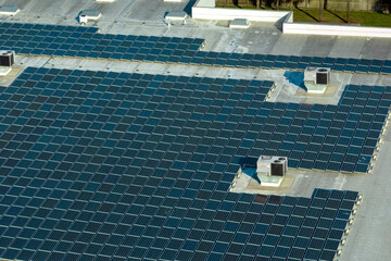 Production of sustainable energy. Aerial view of solar power plant with blue photovoltaic panels...