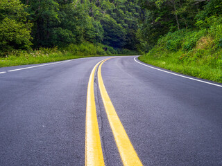 Low angle view of Skyline Drive with yellow center lines in the middle through the Shenandoah National Park, Virginia, USA.