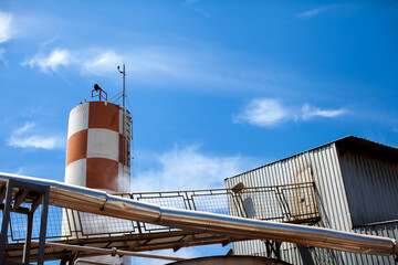 Industry chimney with blue sky and white clouds in the backgroun