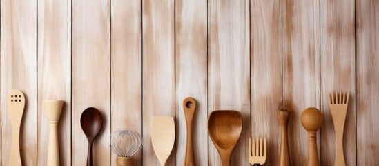 Various kitchen utensils in front of wooden wall with space for text.