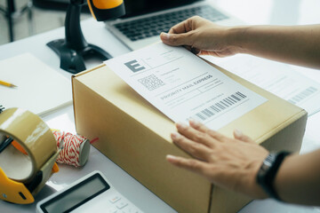 Young business owner putting shipping label on parcel..