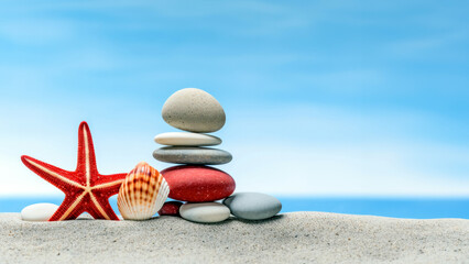 Zen stones and red starfish on the beach with blue sky background. High quality photo