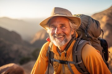 Fototapeta premium Smiling portrait of a happy senior man hiker hiking in the forests and mountains