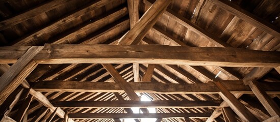 Close-up view of old barn roof from below with wooden rafters.