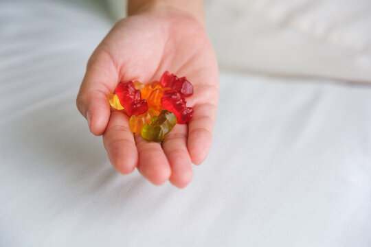 Closeup image of a hand holding colorful jelly gummy bears