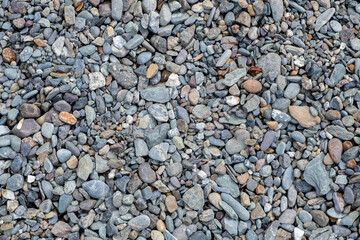 The stones were laid on the ground in the garden as a background. Background blur. Pebble stones background. Crushed stone on the seashore. Selective focus on object. 