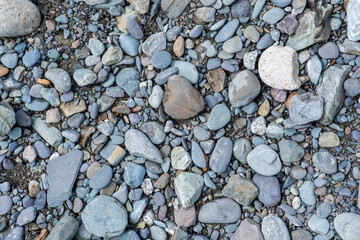 The stones were laid on the ground in the garden as a background. Background blur. Pebble stones background. Crushed stone on the seashore. Selective focus on object. 