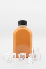 Thai milk tea in plastic bottle with ice cube on isolated background. bottle of cold beverage drink with tea milk.