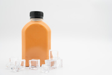 Thai milk tea in plastic bottle with ice cube on isolated background. bottle of cold beverage drink with tea milk.
