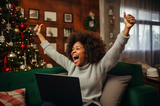 excited african american young woman shopping online using a laptop, surprised or amazed black girl cheering up smiling happy