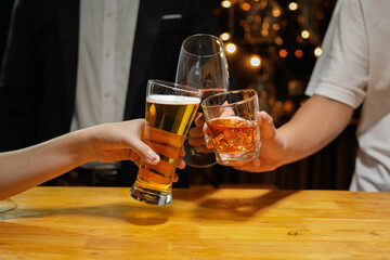 food and drink male friends are happy drinking beer and clinking glasses at a bar or pub.