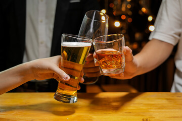 food and drink male friends are happy drinking beer and clinking glasses at a bar or pub.