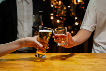 food and drink male friends are happy drinking beer and clinking glasses at a bar or pub.